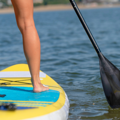 Woman paddleboarding on Okanagan Lake, healthy legs in sun